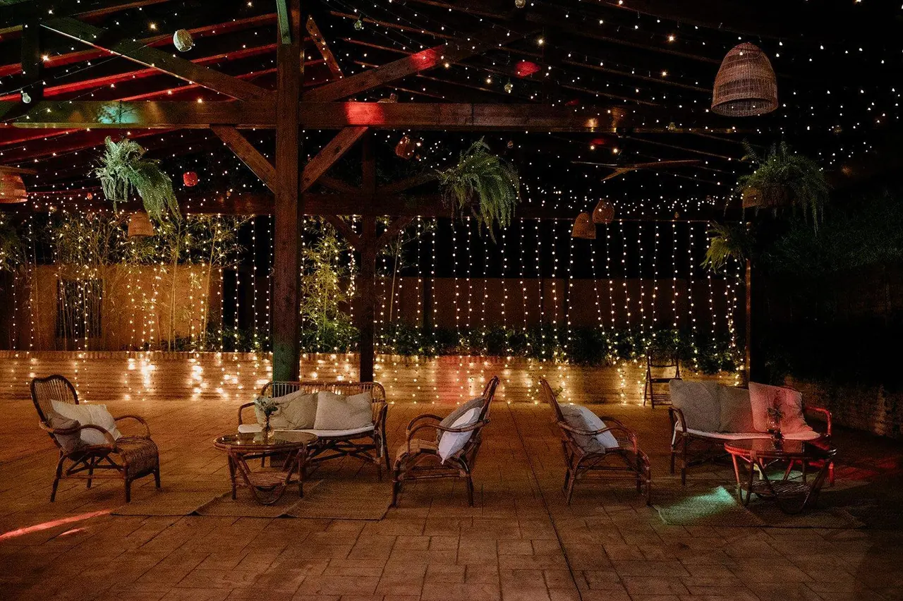 Zona de descanso con butacas bajo cortinas de luces