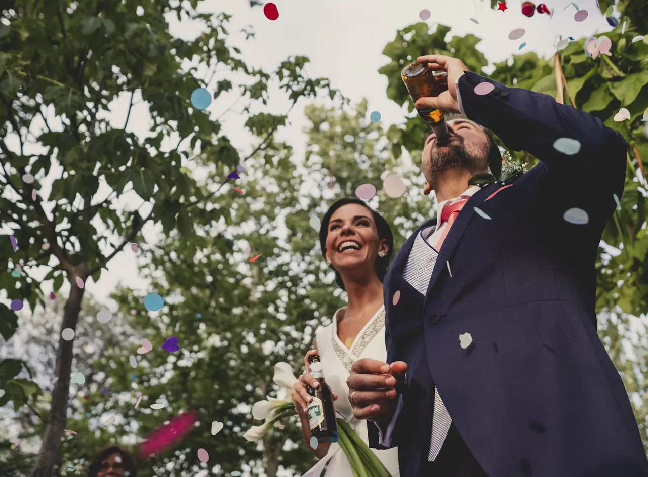 Novios celebrando entre confeti