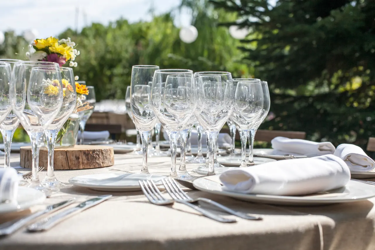 Copas y servilletas en una mesa del banquete, con la luz de la tarde