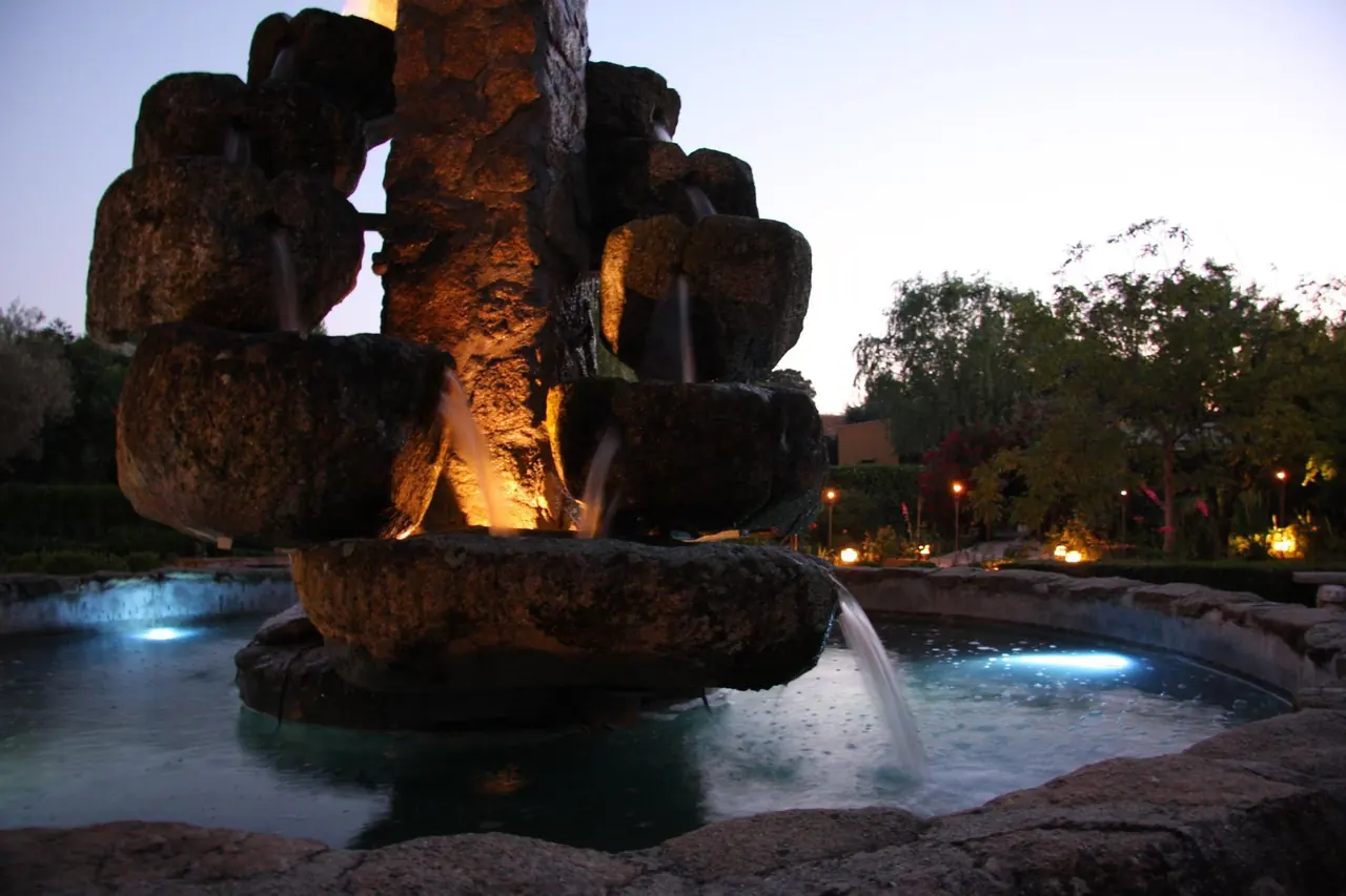 Fuente de piedra iluminada al anochecer