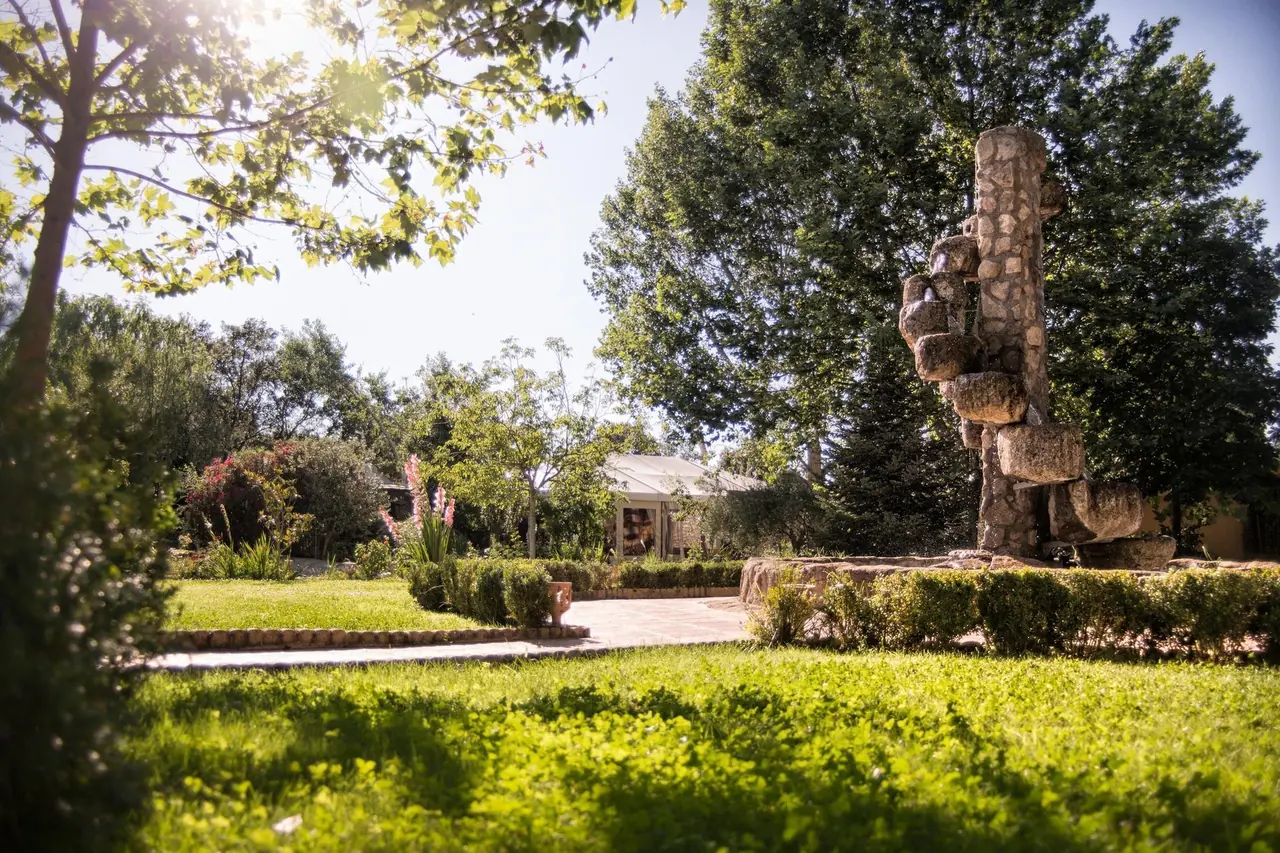 Pradera de césped con la fuente de piedra al fondo