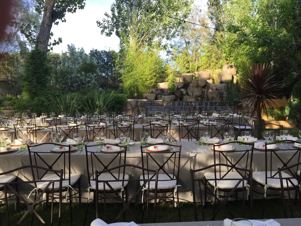 Mesas largas del banquete junto a la cascada