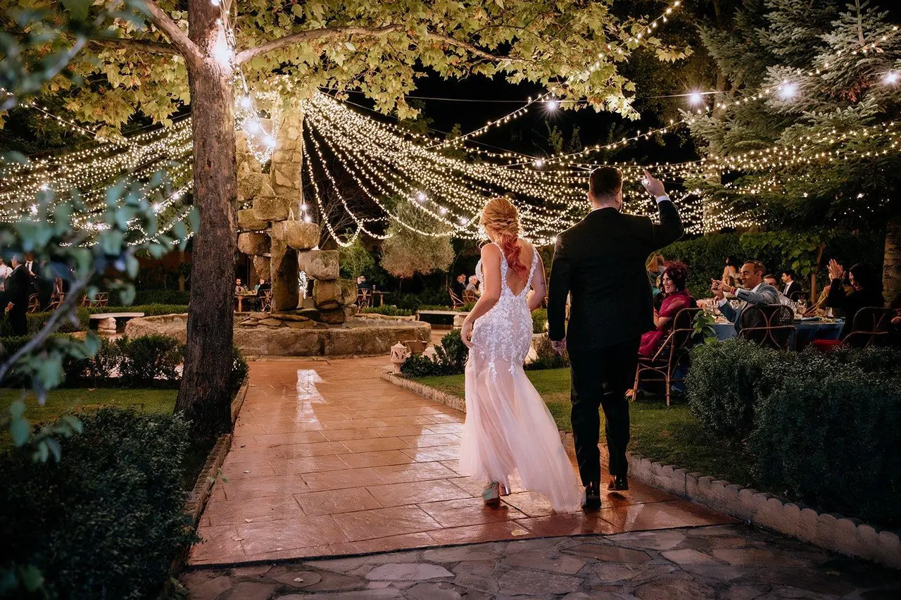 Los novios entran a la cena bajo las guirnaldas de luces