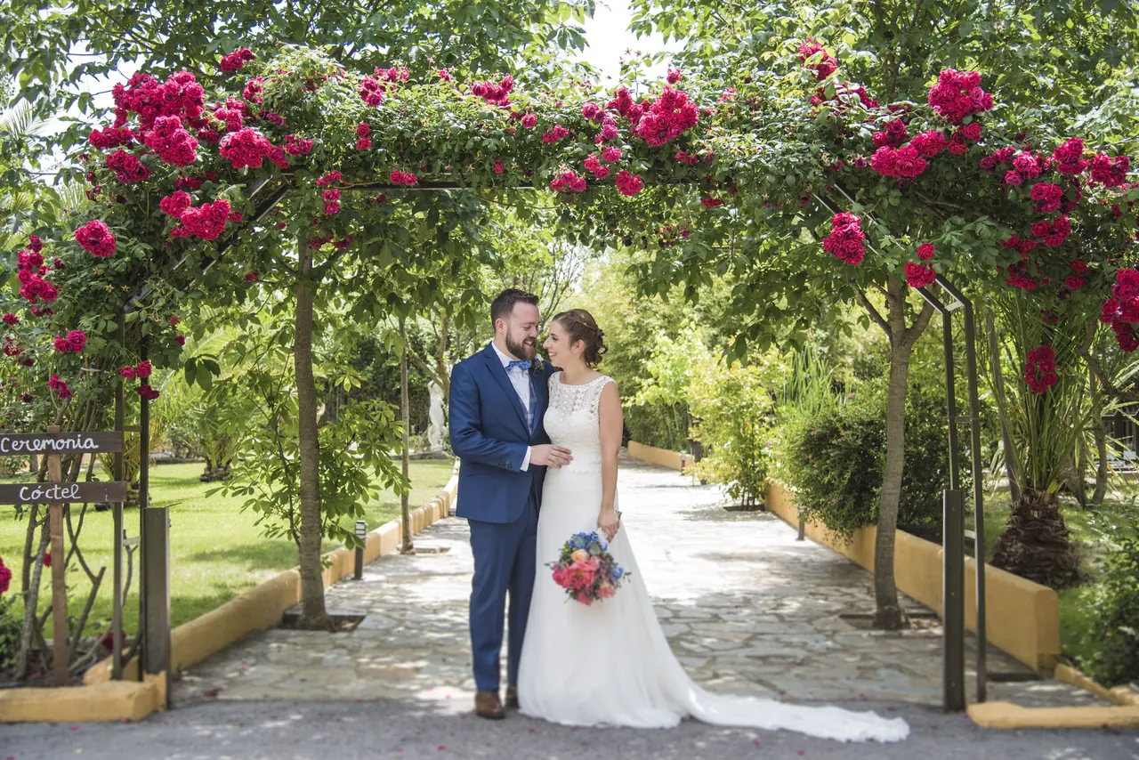 Novios bajo un arco de rosas