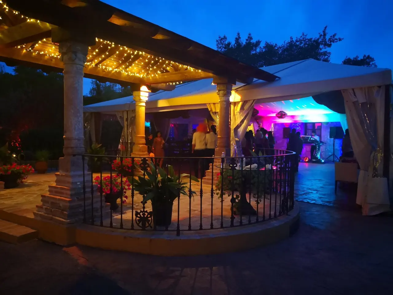 La pérgola iluminada al anochecer, con la pista de baile al fondo