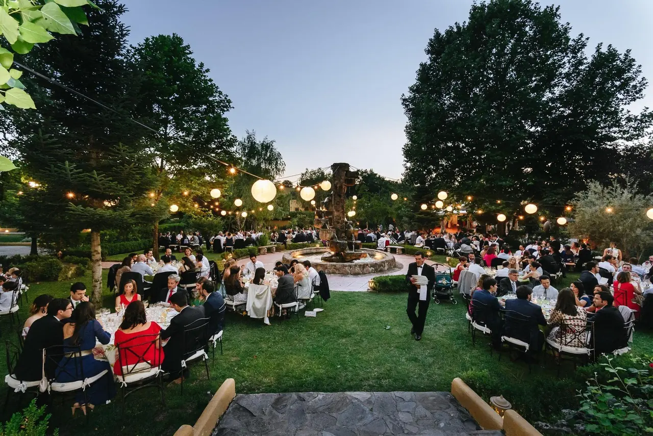 La misma plaza al anochecer, con los invitados cenando bajo farolillos