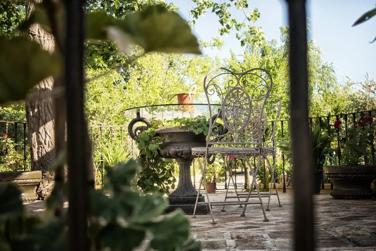Mesa y sillas de forja en un rincón del jardín