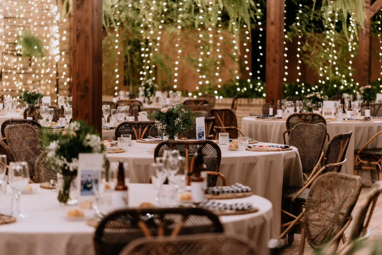 Salón cubierto con cortinas de luces y sillas de mimbre
